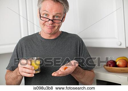 Man with vitamins and orange juice View Large Photo Image Stock Photo - Man with vitamins and orange juice. Fotosearch