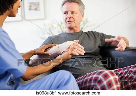 Nurse visiting man with wrist injury View Large Photo Image Stock Image - Nurse visiting man with wrist injury. Fotosearch