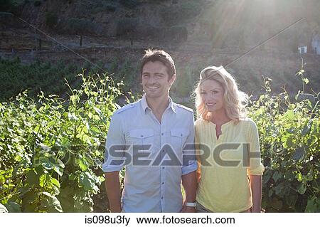 Couple in a sunlit vineyard View Large Photo Image Stock Photo - Couple in a sunlit vineyard. Fotosearch