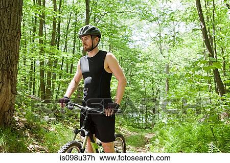 Male cyclist in forest View Large Photo Image Stock Image - Male cyclist in forest. Fotosearch