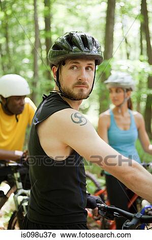 Stock Image - Three cyclists in forest. Fotosearch