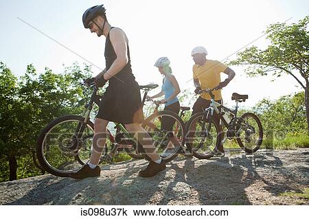Stock Image - Three cyclists, rural scene. Fotosearch