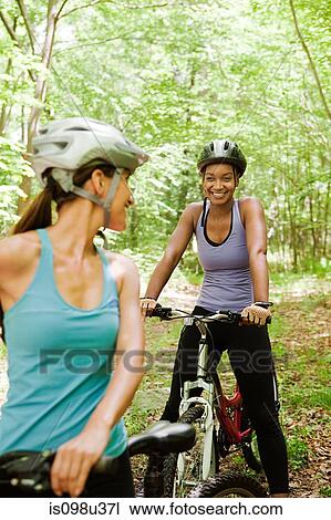 Two female cyclists in forest View Large Photo Image Stock Image - Two female cyclists in forest. Fotosearch