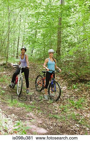 Two female cyclists in forest View Large Photo Image Stock Image - Two female cyclists in forest. Fotosearch
