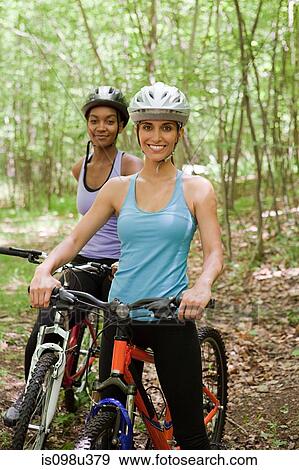 Two female cyclists in forest View Large Photo Image Stock Photo - Two female cyclists in forest. Fotosearch