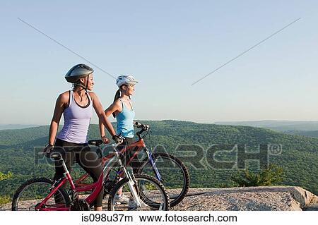 Two female cyclists, rural scene View Large Photo Image Picture - Two female cyclists, rural scene. Fotosearch