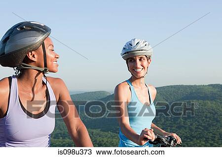 Two female cyclists, rural scene View Large Photo Image Stock Image - Two female cyclists, rural scene. Fotosearch
