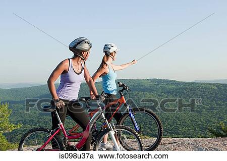 Two female cyclists, rural scene View Large Photo Image Stock Image - Two female cyclists, rural scene. Fotosearch