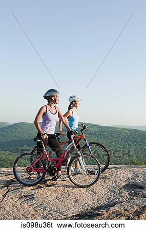 Stock Photograph - Two female cyclists, rural scene. Fotosearch