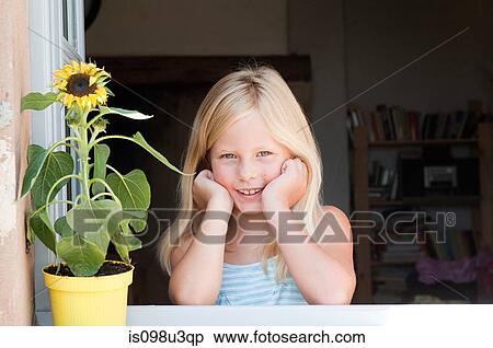 Stock Photography - Blond girl with sunflower, portrait. Fotosearch