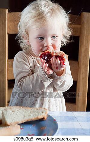Female toddler eating bread and jam View Large Photo Image Stock Photography - Female toddler eating bread and jam. Fotosearch