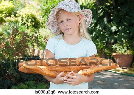 Girl in sunhat holding baguettes View Large Photo Image Stock Photo - Girl in sunhat holding baguettes. Fotosearch