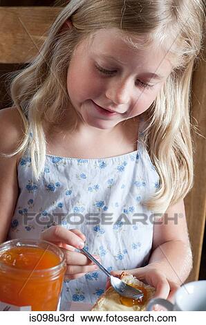 Girl spreading jam on bread View Large Photo Image Stock Image - Girl spreading jam on bread. Fotosearch