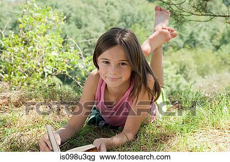 Girls lying on front with book View Large Photo Image Stock Image - Girls lying on front with book. Fotosearch
