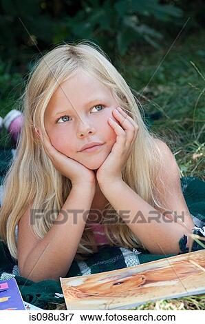 Girls lying on front with book View Large Photo Image Stock Photo - Girls lying on front with book. Fotosearch
