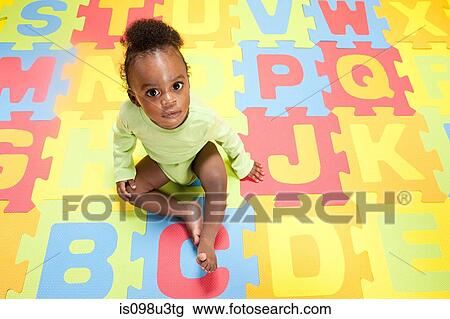 Stock Image - Baby boy playing with toy alphabet letters. Fotosearch