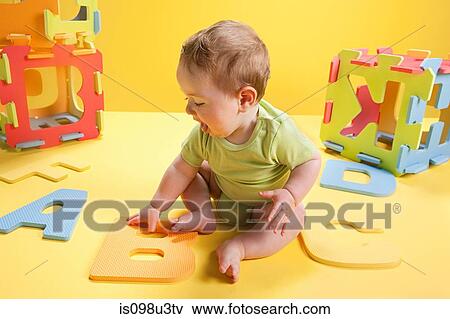 Baby boy playing with toy alphabet letters View Large Photo Image Stock Photo - Baby boy playing with toy alphabet letters. Fotosearch