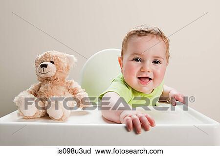 Baby boy sitting in highchair with teddy bear View Large Photo Image Stock Image - Baby boy sitting in highchair with teddy bear. Fotosearch