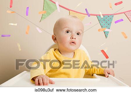 Baby boy sitting in highchair with bunting View Large Photo Image Stock Image - Baby boy sitting in highchair with bunting. Fotosearch