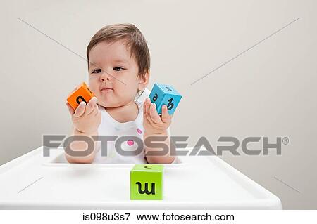 Baby boy sitting in highchair with wooden alphabet blocks View Large Photo Image Stock Photo - Baby boy sitting in highchair with wooden alphabet blocks. Fotosearch