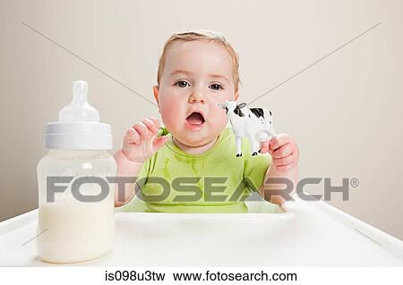 Baby boy with bottle of milk and toy cow View Large Photo Image Stock Photo - Baby boy with bottle of milk and toy cow. Fotosearch