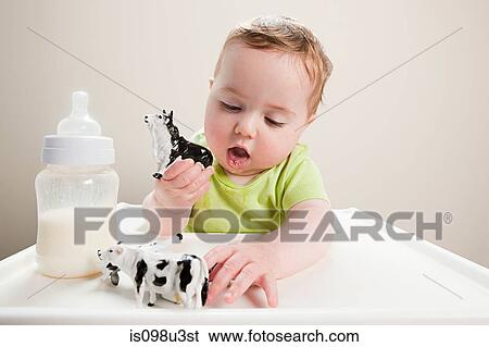 Baby boy with bottle of milk and toy cow View Large Photo Image Stock Photograph - Baby boy with bottle of milk and toy cow. Fotosearch
