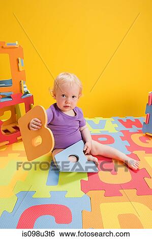 Baby girl playing with toy alphabet letters View Large Photo Image Stock Photograph - Baby girl playing with toy alphabet letters. Fotosearch
