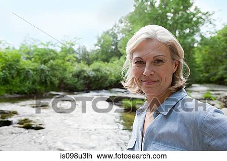 Stock Image - Mature woman in rural scene. Fotosearch