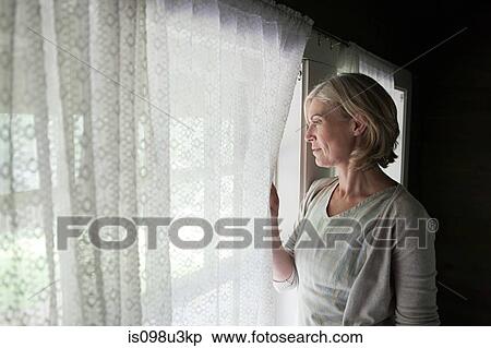 Mature woman looking out of window View Large Photo Image Stock Photography - Mature woman looking out of window. Fotosearch