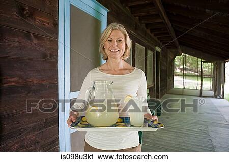 Stock Photograph - Mature woman with tray of lemonade. Fotosearch