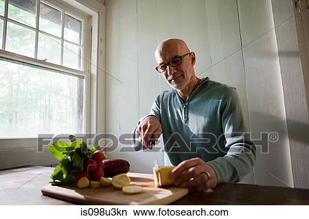 Picture - Senior man preparing food indoors. Fotosearch