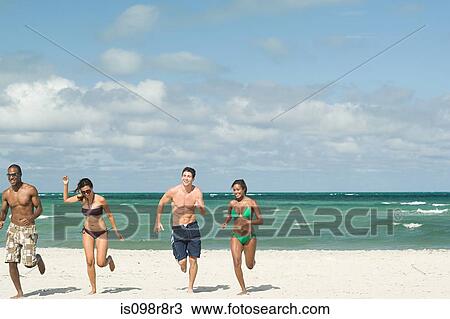 Stock Image - Friends running on the beach. Fotosearch