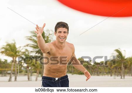 Stock Photograph - Young man throwing flying disc. Fotosearch