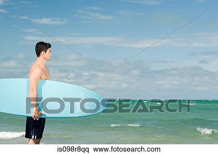 Stock Photography - Young man with surfboard. Fotosearch