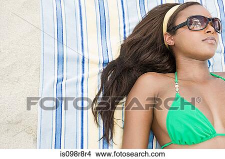 Young woman sunbathing View Large Photo Image Picture - Young woman sunbathing. Fotosearch