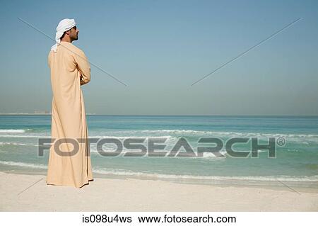 Middle Eastern man looking at sea, portrait View Large Photo Image Stock Photograph - Middle Eastern man looking at sea, portrait. Fotosearch