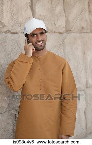 Middle Eastern man using mobile phone View Large Photo Image Stock Photograph - Middle Eastern man using mobile phone. Fotosearch