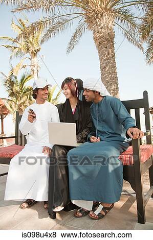 Stock Photo - Middle Eastern people with laptop and mobile phone. Fotosearch