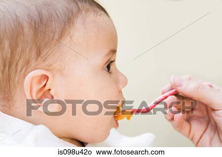 Picture - Baby boy being fed. Fotosearch