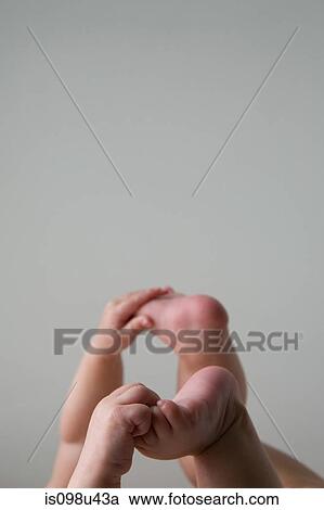 Stock Image - Baby holding feet. Fotosearch