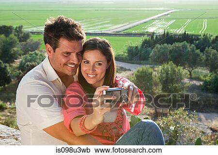 Stock Image - Young couple photographing themselves. Fotosearch