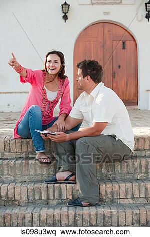 Stock Photography - Young couple sitting on steps. Fotosearch