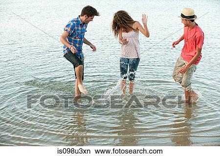 Picture - Three friends having fun in lake. Fotosearch