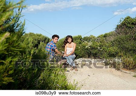 Young couple sitting on sand View Large Photo Image Stock Photo - Young couple sitting on sand. Fotosearch