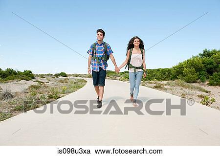 Young couple walking down rural road View Large Photo Image Stock Image - Young couple walking down rural road. Fotosearch