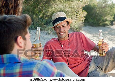 Young friends sitting on sand with beer View Large Photo Image Stock Photography - Young friends sitting on sand with beer. Fotosearch