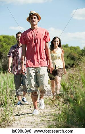 Stock Photo - Young friends walking along rural path. Fotosearch