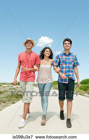 Stock Photo - Young friends walking down rural road. Fotosearch