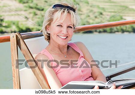 Mature reading book woman on a boat holiday View Large Photo Image Stock Photography - Mature reading book woman on a boat holiday. Fotosearch