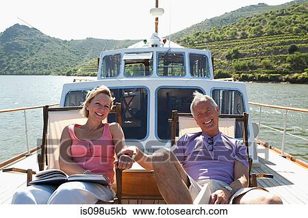 Senior couple sitting on deckchairs on a boat View Large Photo Image Stock Image - Senior couple sitting on deckchairs on a boat. Fotosearch